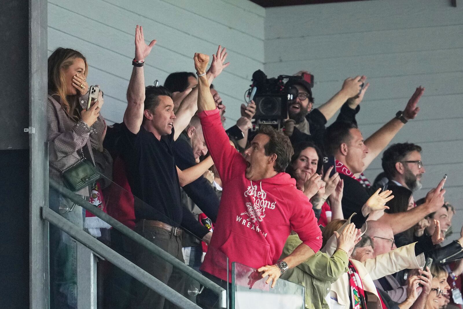 Wrexham co-owners Ryan Reynolds, center, and Rob McElhenney celebrate at the end of the English League One soccer match between Wrexham and Charlton Athletic at the Racecourse ground in Wrexham, Wales, Saturday, April 26, 2025. (AP Photo/Jon Super)