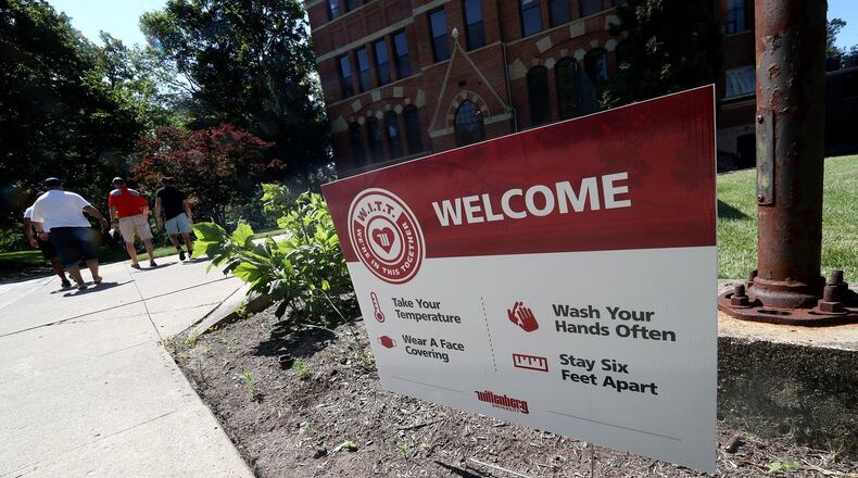 Signs, reminding visitors about Covid-19 precautions, are placed aroung the admissions office at Wittenberg Univsersity. BILL LACKEY/STAFF
