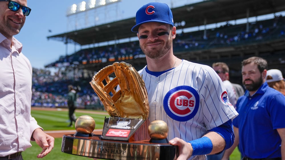FILE - Chicago Cubs' Ian Happ (8) holds his Gold Glove Award trophy before a baseball game against the Cincinnati Reds, Saturday, May 31, 2025, in Chicago. (AP Photo/Erin Hooley, File)