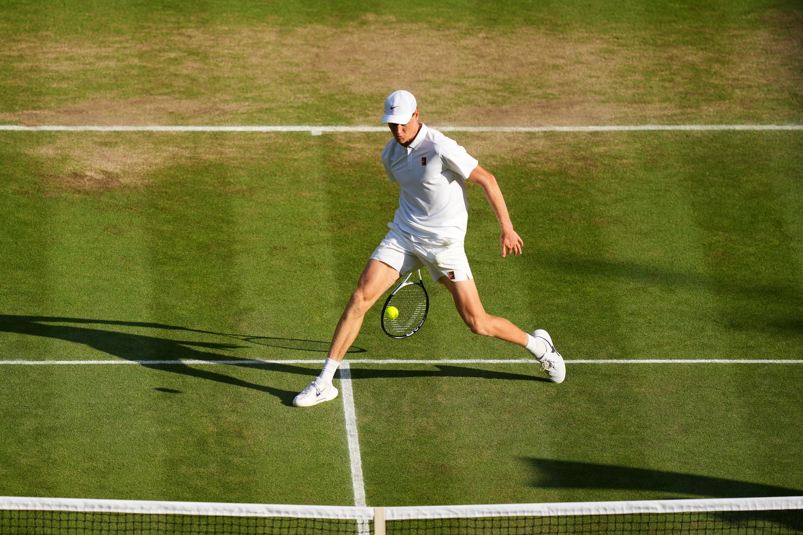 Italy's Jannik Sinner returns to Carlos Alcaraz of Spain in the men's singles final at the Wimbledon Tennis Championships in London, Sunday, July 13, 2025. (AP Photo/Joanna Chan)