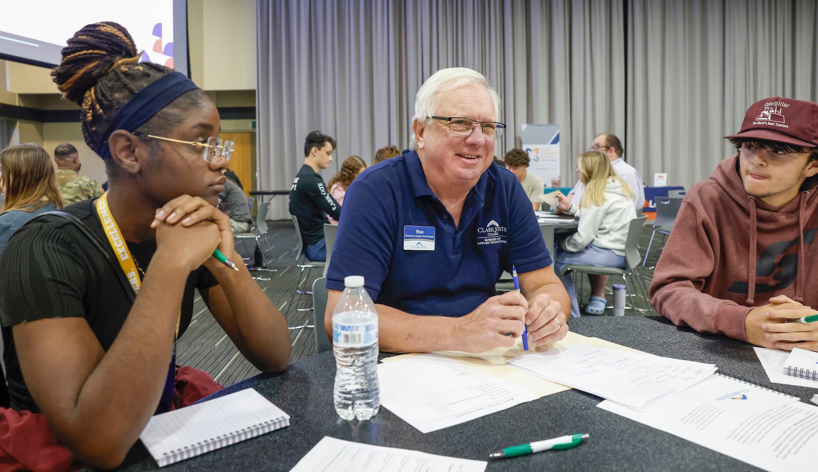 Clark State career navigator Ron Bolender, center, talks with Springfield High school junior Berlineda Auguste, left, and Northwestern High School junior Ricky Smith about different job opportunities during Discovery Day on Tuesday, September 30, 2025, at the Hollenbeck Bayley Center. JOSEPH COOKE/STAFF