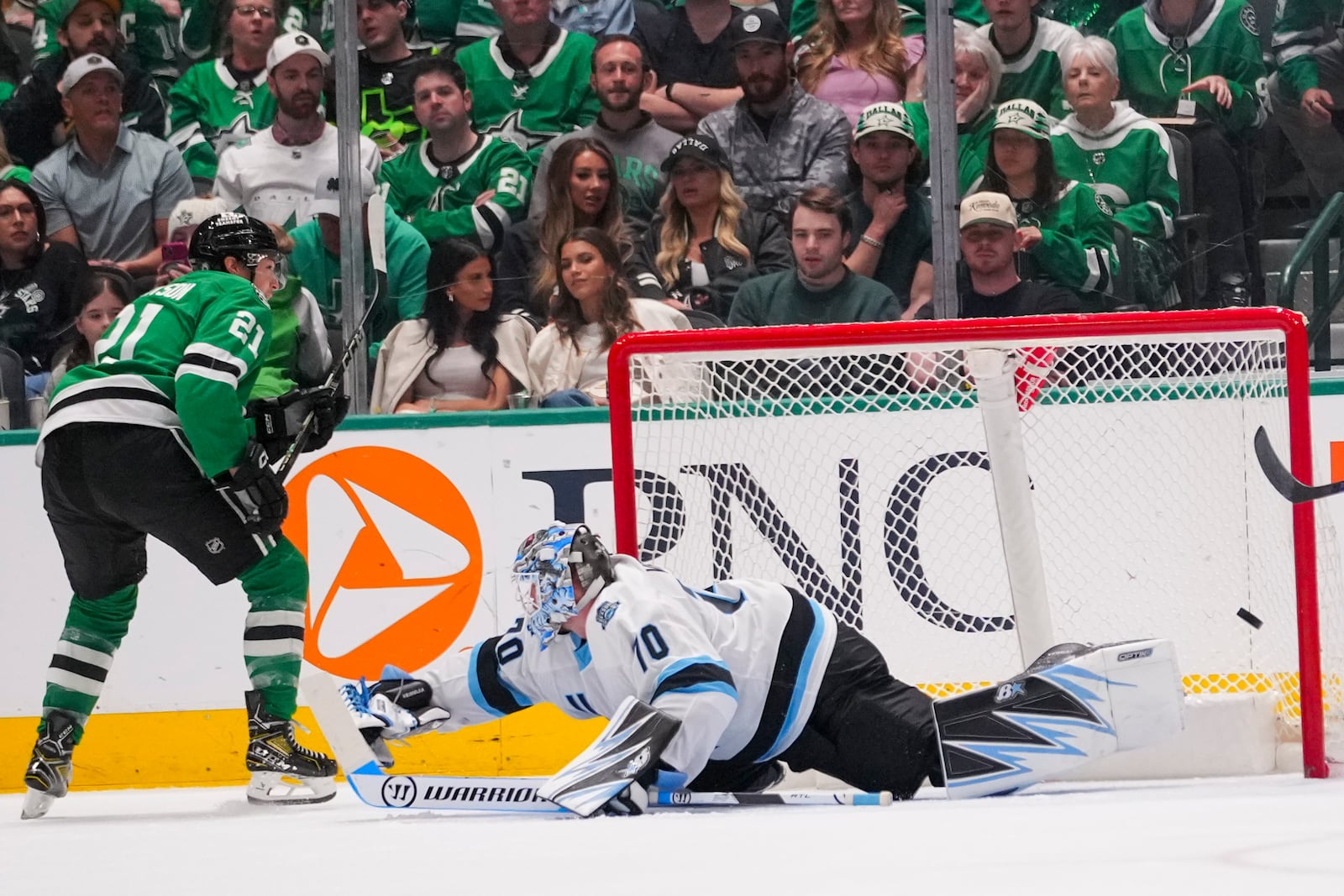 Dallas Stars left wing Jason Robertson, left, scores a goal on Utah Hockey Club goaltender Karel Vejmelka during the second period of an NHL hockey game Saturday, April 12, 2025, in Dallas. (AP Photo/Julio Cortez)