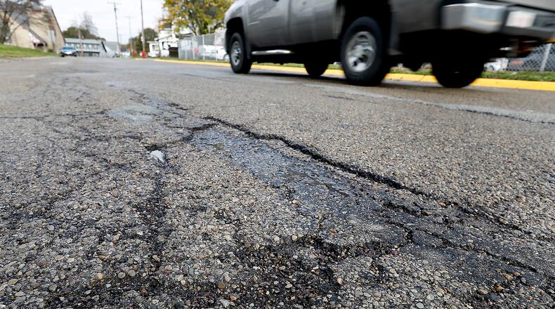 The cracked and broken asphalt along Church Street in South Charleston. Voters approved a roads levy, which would raise $954k over 8 years through a 0.25 percent income tax increase. Bill Lackey/Staff