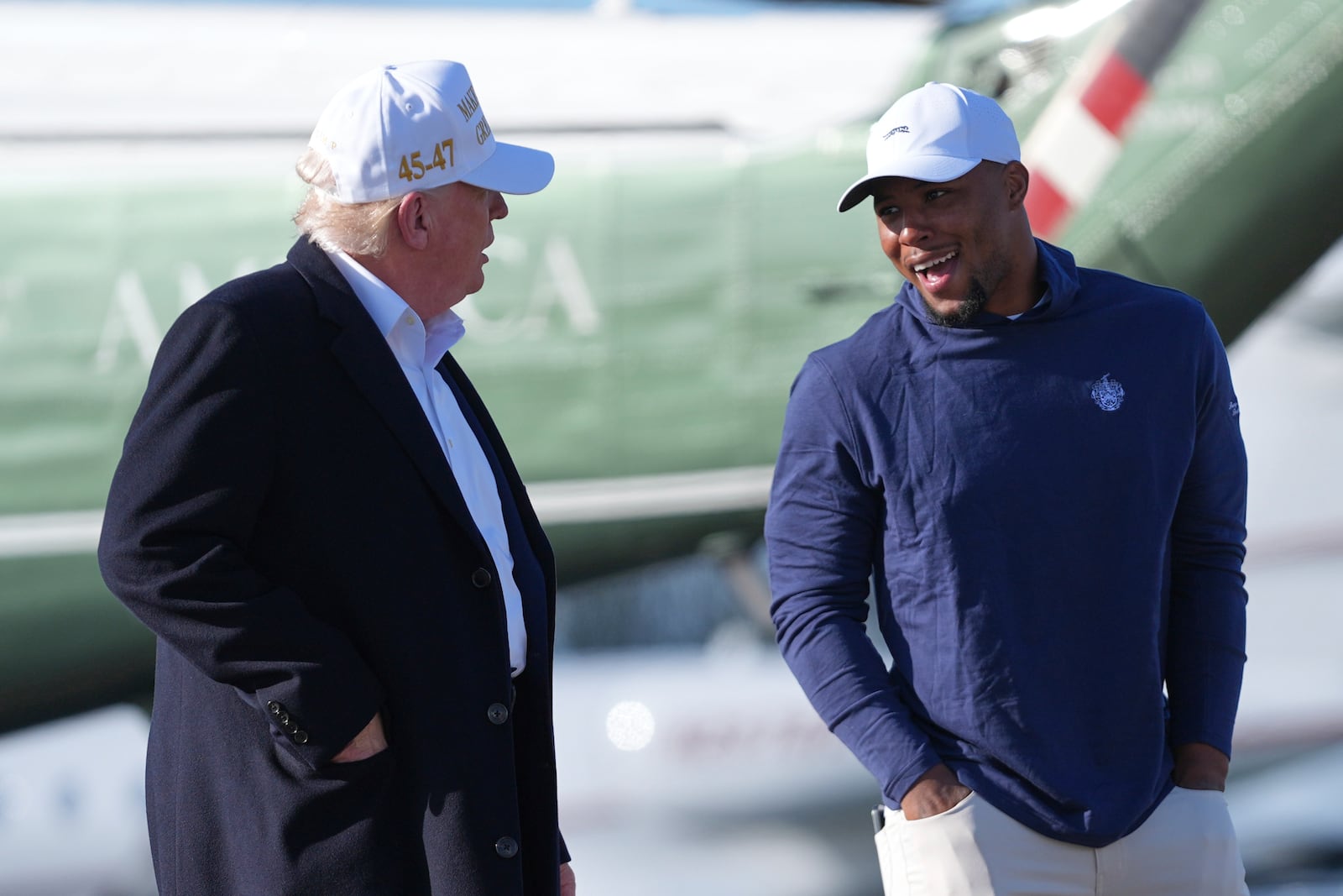 President Donald Trump, left, walks with Philadelphia Eagles football player Saquon Barkley before boarding Air Force One at Morristown Municipal Airport, Sunday, April 27, 2025, in Morristown, N.J. (AP Photo/Evan Vucci)
