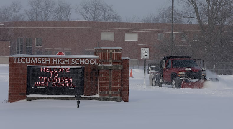 A snow plow cleans several inches of snow off the Tecumseh High School parking lot Tuesday morning. Area schools were closed or working virtually from home due to the weather. BILL LACKEY/STAFF