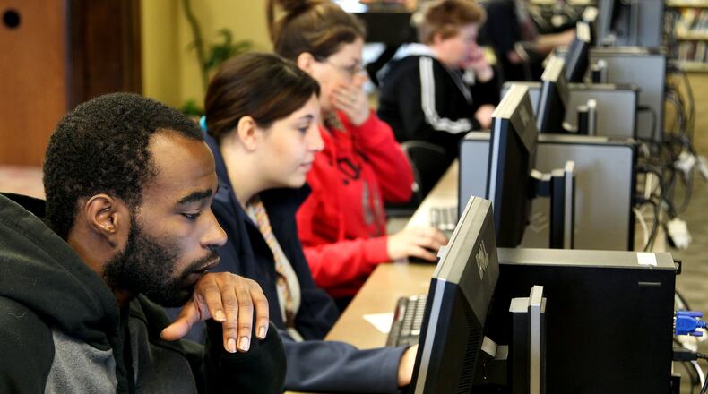 Jacob Brown, 23, (left) searches for jobs at the Lane Library Hamilton branch Tuesday, April 23, 2013. In 2013, about 72 percent of Ohio residents had high-speed broadband service at home, up 1 percentage point from 2012 and 6 percentage points from 2011, according to a survey of Connect Ohio. NICK DAGGY / STAFF