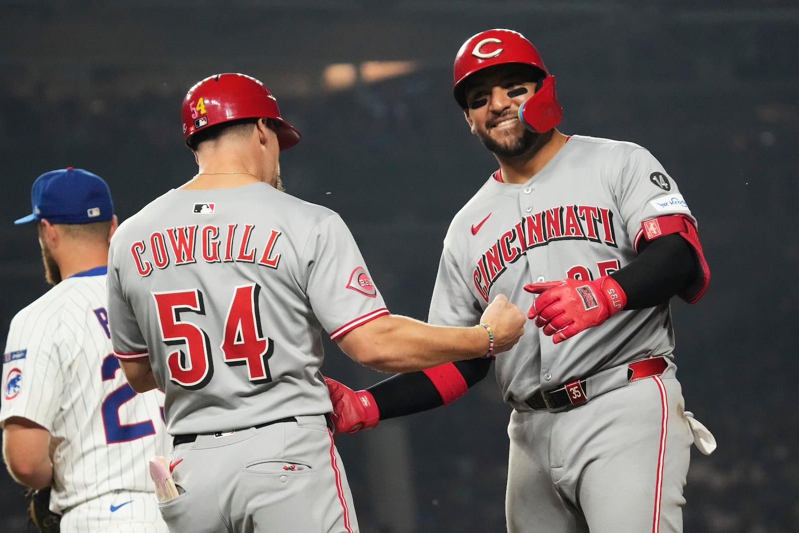 Cincinnati Reds' Jose Trevino, right, celebrates with first base coach Collin Cowgill after hitting a single during the seventh inning of a baseball game against the Chicago Cubs in Chicago, Tuesday, Aug. 5, 2025. (AP Photo/Nam Y. Huh)