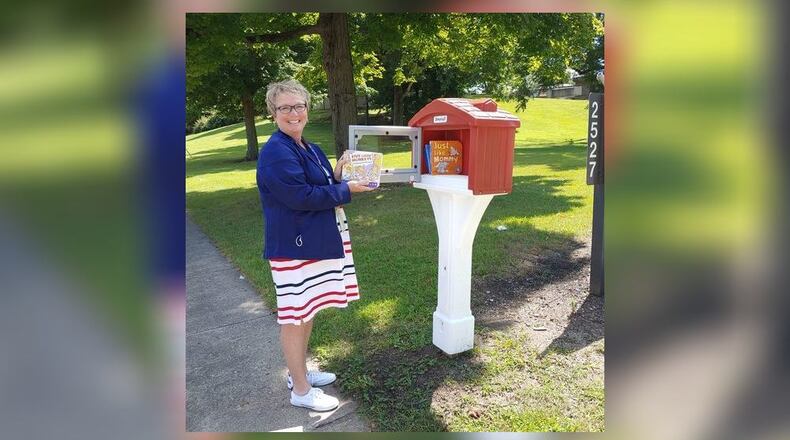 Shannon Chatfield, Director of the Early Childhood department for Developmental Disabilities of Clark County, places books into the new Little Free Library on the Clark DD campus at 2527 Kenton Street. Contributed