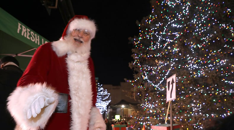 Santa makes his way back to his carriage after the lighting of the Springfield Christmas tree during the Holiday in the City celebration in 2019. The event was cancelled in 2020 because of the COVID-19 pandemic.  BILL LACKEY/STAFF