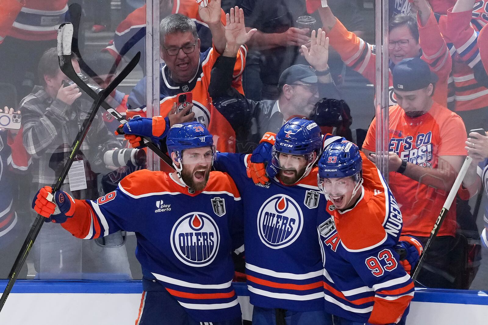 Edmonton Oilers' Leon Draisaitl, from left to right, Evan Bouchard, and Ryan Nugent-Hopkins celebrate Draisaitl's winning goal during the first overtime period in Game 1 of the NHL Stanley Cup Final against the Florida Panthers, in Edmonton, Alberta, on Wednesday, June 4, 2025. (Darryl Dyck/The Canadian Press via AP)