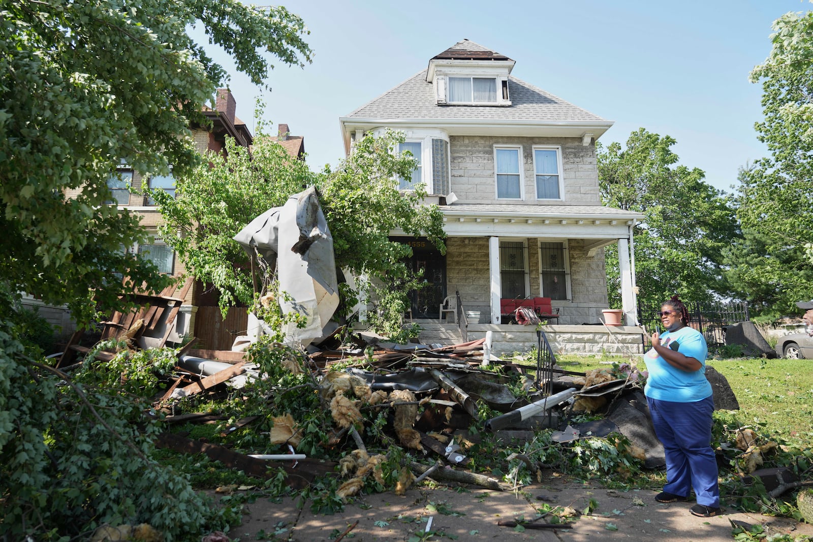 People survey damage after a severe storm moved through Friday, May 16, 2025, in St. Louis. (AP Photo/Jeff Roberson)