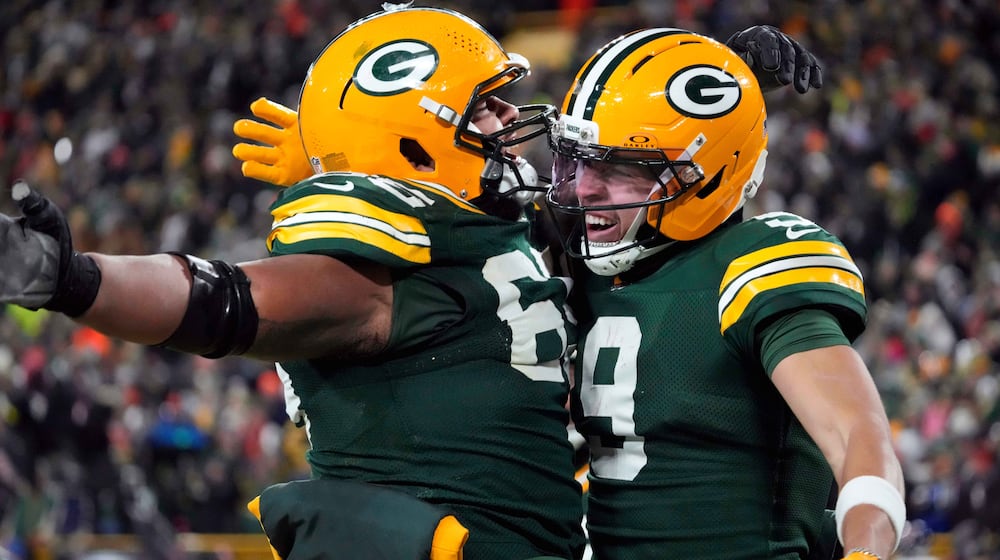 Green Bay Packers wide receiver Christian Watson (9) celebrates with guard Aaron Banks (65) after scoring a touchdown against the Chicago Bears during the second half of an NFL football game Sunday, Dec. 7, 2025, in Green Bay, Wis. (AP Photo/Morry Gash)