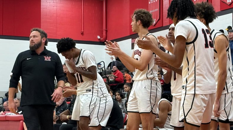 Wayne head coach Nathan Martindale and his players celebrate a 71-51 win against Centerville Tuesday, Dec. 16, 2025, in Huber Heights. STEVEN WRIGHT / STAFF