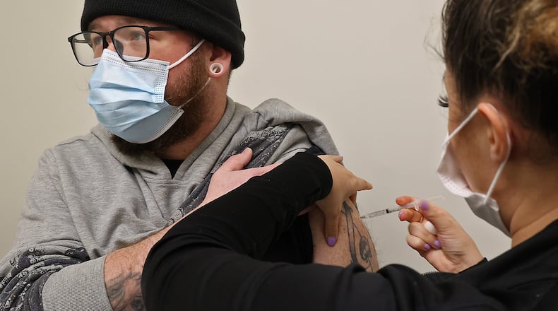 Eric Miller gets his first COVID vaccine shot from Brooke Garrett at the Clark County Combined Health District office in the Southern Village Shopping Center Friday, Feb. 25, 2022. BILL LACKEY/STAFF