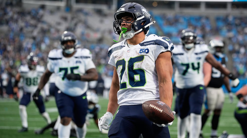 Seattle Seahawks running back Zach Charbonnet celebrates after scoring against the Carolina Panthers during the second half of an NFL football game, Sunday, Dec. 28, 2025, in Charlotte, N.C. (AP Photo/Jacob Kupferman)