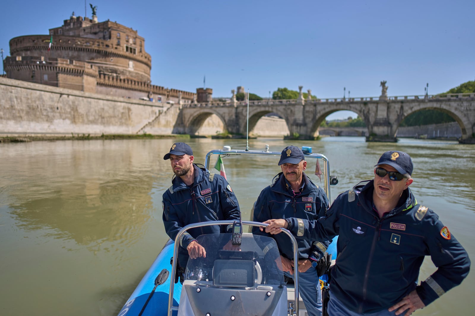 Italian police officers on a dinghy boat patrol for security the Tiber river near the Vatican, with the Sant'Angelo castle in the background, Tuesday, April 22, 2025. (AP Photo/Bernat Armangue)