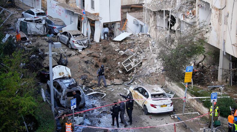 Israeli security and rescue forces respond at the site of an Iranian missile strike in Tel Aviv, Israel, Tuesday, March 24, 2026. (AP Photo/Ohad Zwigenberg)