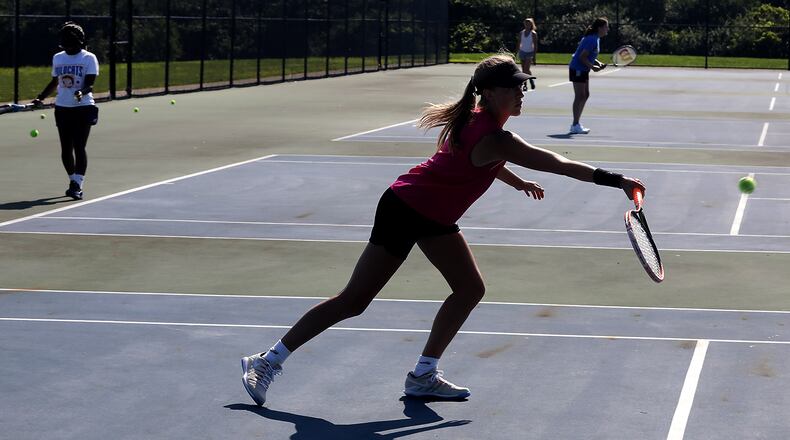 The Springfield High School girls tennis team practices Friday in the morning sun. Tennis is one of the safest sports for social distancing. Students will begin school in Clark and Champaign counties starting this month under new rules aimed at preventing the spread of the coronavirus. BILL LACKEY/STAFF