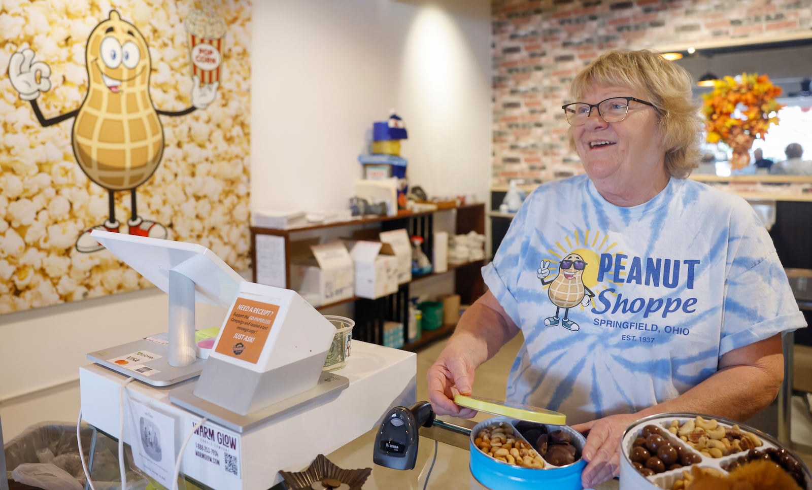 Worker Patty Luther laughs while organizing peanuts at the Peanut Shoppe on Wednesday, September 3, 2025, in Springfield. Her brother Matt Luther is the store owner. JOSEPH COOKE/STAFF 