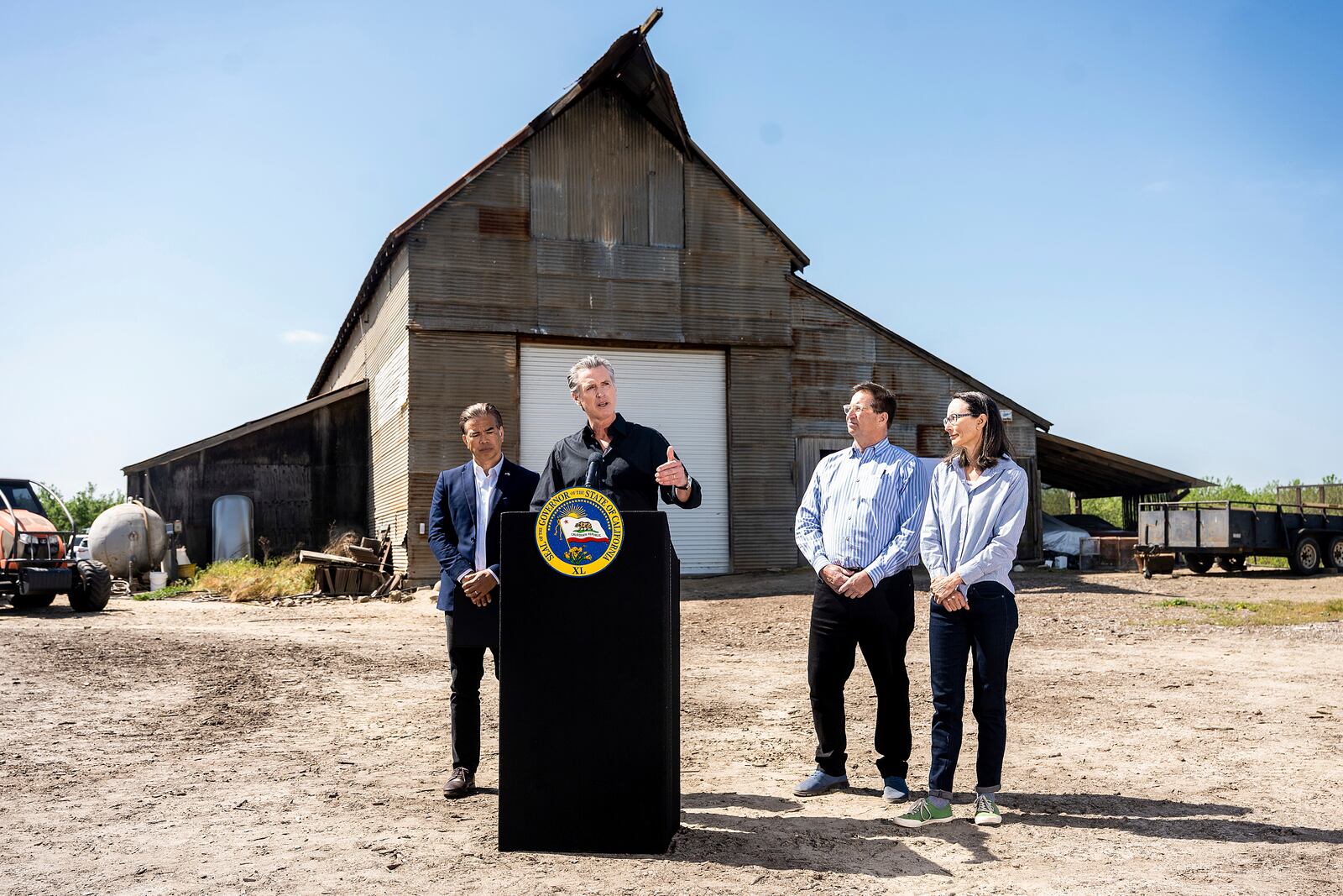 California Gov. Gavin Newsom discusses President Donald Trump's tariffs, as California Attorney General Rob Bonta, left, Sierra Pacific Warehouse Group CEO Chris Murphy and almond farmer Christine Gemperle, listen, during a press conference on Wednesday, April 16, 2025, at an almond farm in Ceres, Calif. (AP Photo/Noah Berger)