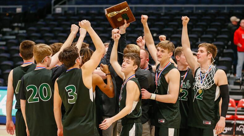 The Catholic Central boys basketball team celebrates with trophy after beating Jackson Center to win its third district title in five years. CONTRIBUTED PHOTO BY MICHAEL COOPER