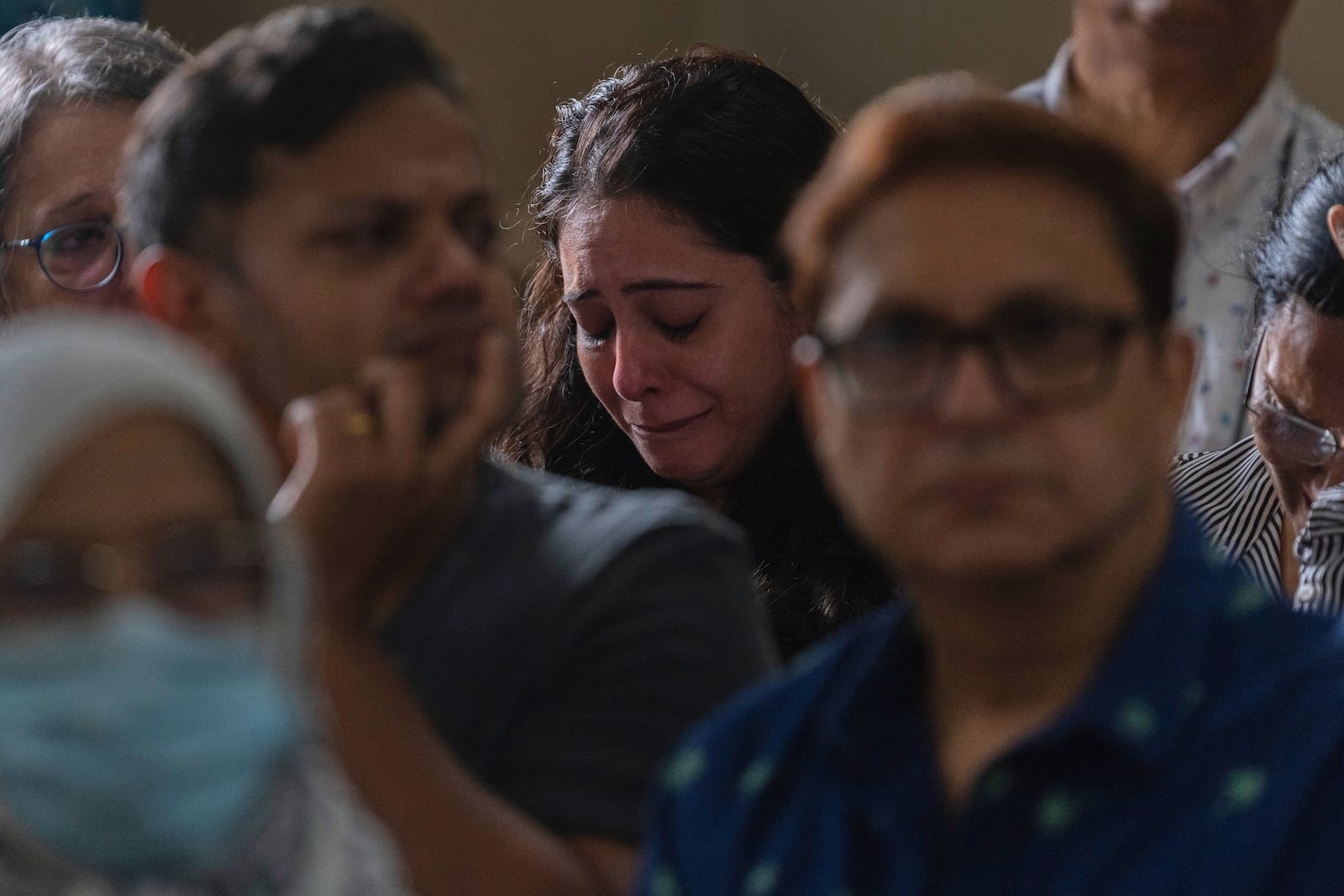 A relative of the crew of the Air India flight that crashed in Ahmedabad last month, mourns during a prayer meeting at a church in Mumbai, India, Saturday, July 12, 2025. (AP Photo/ Rafiq Maqbool)