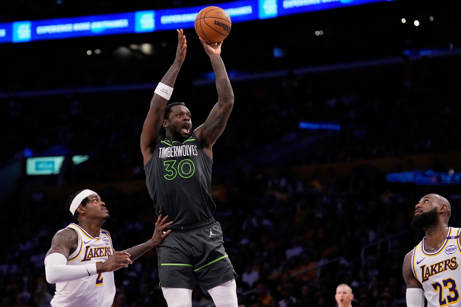 Minnesota Timberwolves forward Julius Randle, center, shoots as Los Angeles Lakers forward Jarred Vanderbilt, left, and forward LeBron James defend during the second half in Game 1 of an NBA first-round playoff series Saturday, April 19, 2025, in Los Angeles. (AP Photo/Mark J. Terrill)