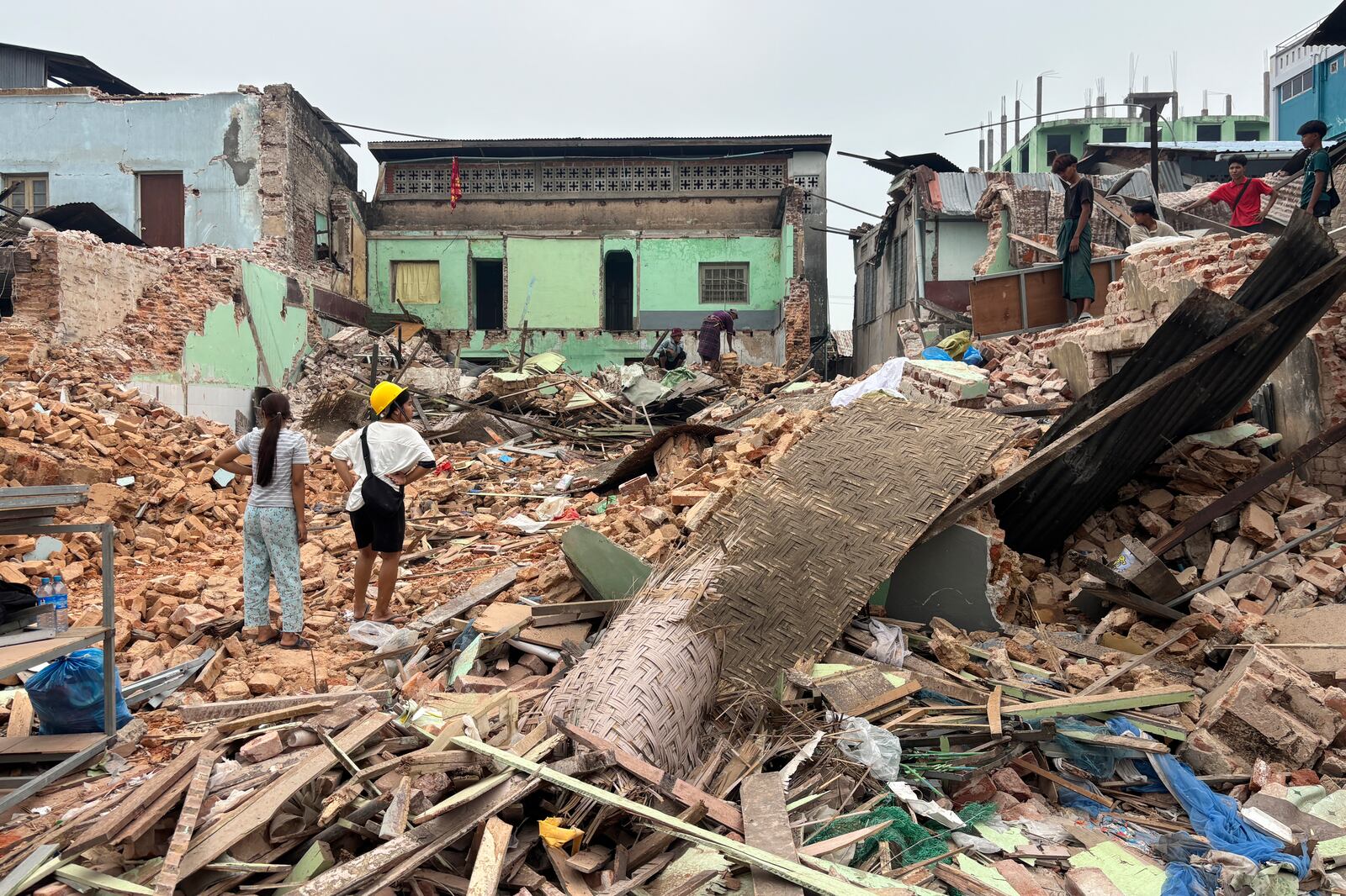 People clean debris from damaged buildings in the aftermath of an earthquake on March 28, in Naypyitaw, Myanmar, Monday, April 7, 2025. (AP Photo)