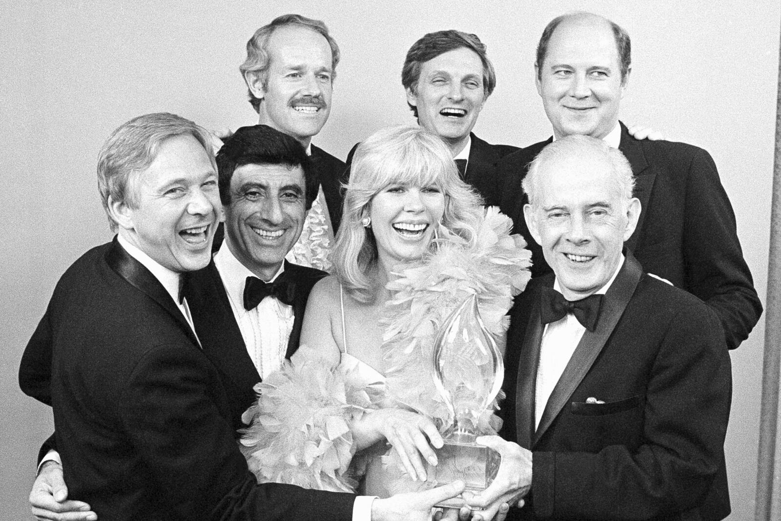 FILE - Cast members from "M*A*S*H," foreground from left, William Christopher, Jamie Farr, Loretta Swit and Henry Morgan, back row from left, Mike Farrell, Alan Alda and William Ogden Stiers, pose with their People's Choice Award for best comedy series in Santa Monica, Calif., on March 19, 1982. (AP Photo/Doug Pizac, File)