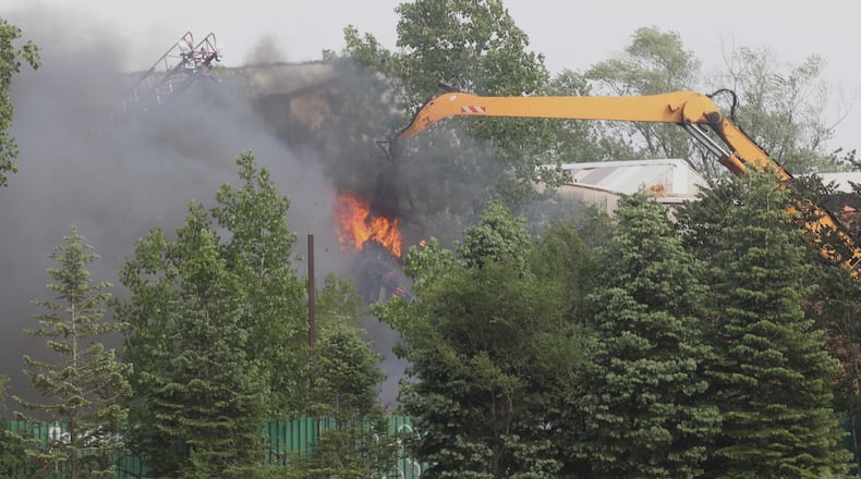 Heavy machinery was used to help move a burning rubbish pile to help put the fire out Tuesday afternoon, May 25, 2021, at Staker Alloys recycler in Springfield. BILL LACKEY/STAFF