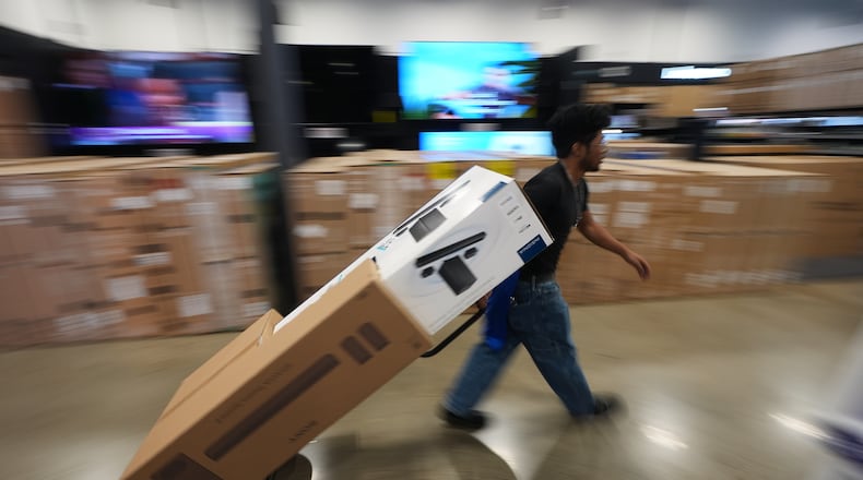 A Best Buy employee hauls early Black Friday sale items at Best Buy Thursday, Nov. 20, 2025, in San Diego. (AP Photo/Gregory Bull)