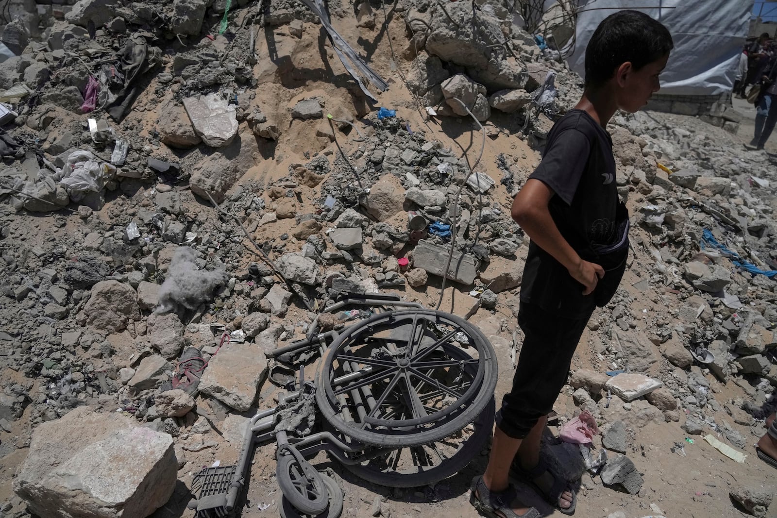 A kid stands next to the rubbles following an Israeli strike on tents sheltering displaced Palestinians in Gaza City on Tuesday, July 8, 2025. (AP Photo/Jehad Alshrafi)
