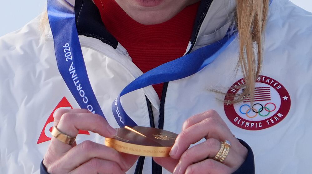 United States' Mikaela Shiffrin looks at her gold medal in an alpine ski, women's slalom race, at the 2026 Winter Olympics, in Cortina d'Ampezzo, Italy, Wednesday, Feb. 18, 2026. (AP Photo/Jacquelyn Martin)