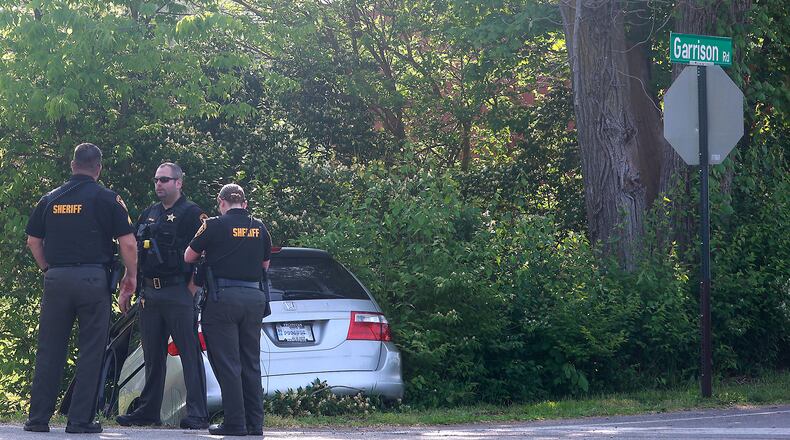 Springfield police and the Clark County Sheriff's Office investigate the scene at the intersection of Fairfield Pike and Garrison Road, where a minivan crashed Monday, May 22, 2023 while being pursued from Selma Road in Springfield. Three people reportedly were involved in the crash, and one of them was transported by medical helicopter. One was not injured and the third fled the scene and was later captured in a nearby field. A fourth individual jumped out of the car soon after the pursuit began in Springfield. BILL LACKEY/STAFF
