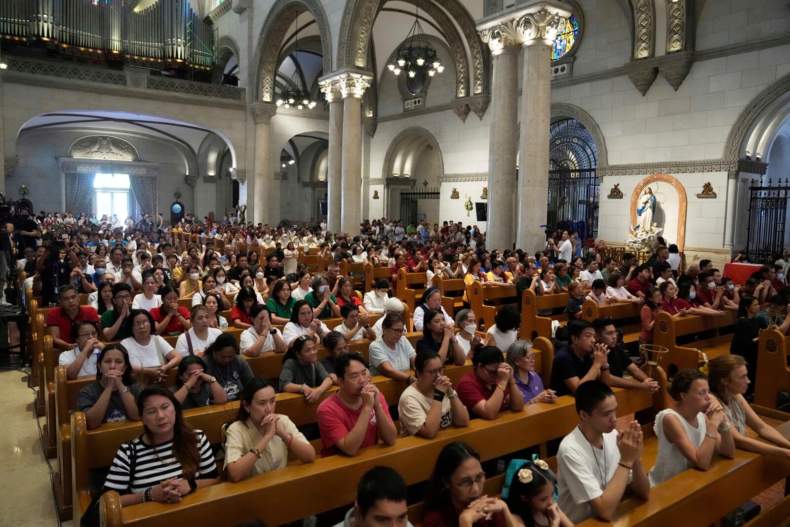 Catholics attend a mass for the late Pope Francis at the Manila Cathedral in the country's capital, Philippines Tuesday April 22, 2025. (AP Photo/Aaron Favila)
