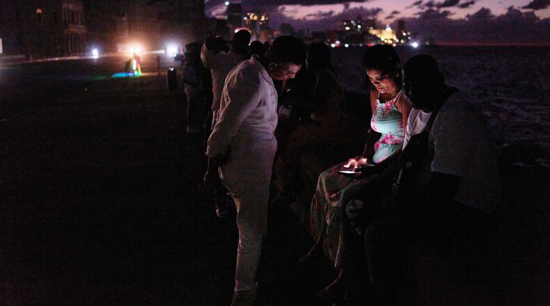 People spend the night in the dark on the Malecon during a blackout in Havana, Cuba, Saturday, March 21, 2026. (AP Photo/Ramon Espinosa)