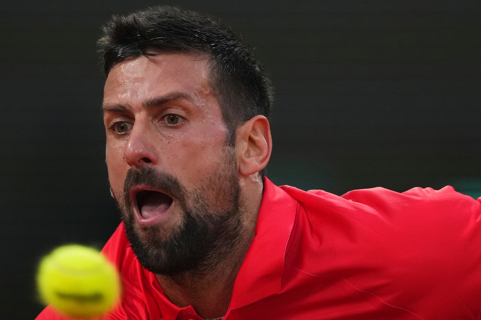 Serbia's Novak Djokovic reaches for the ball against Austria's Filip Misolic during their third-round match of the French Tennis Open at the Roland-Garros stadium in Paris, Saturday, May 31, 2025. (AP Photo/Lindsey Wasson)