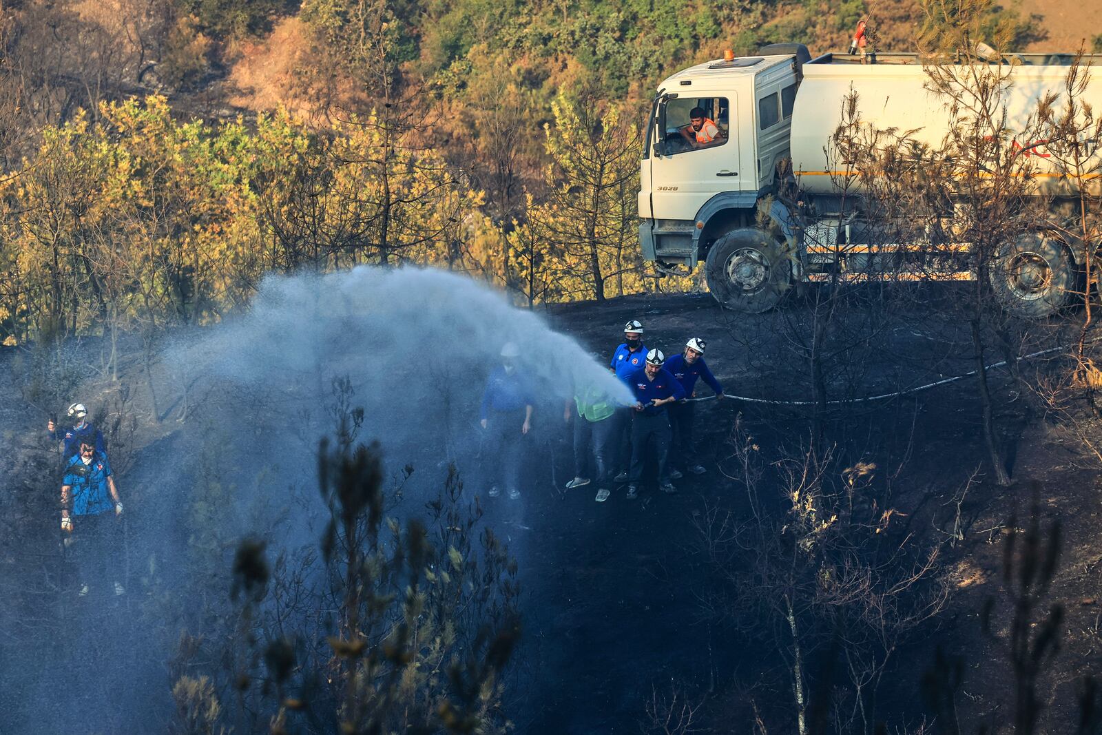 Firefighters work to extinguish a wildfire in Bursa, Turkey, Sunday, July 27, 2025. (Sercan Ozkurnazli/DIA Images via AP)