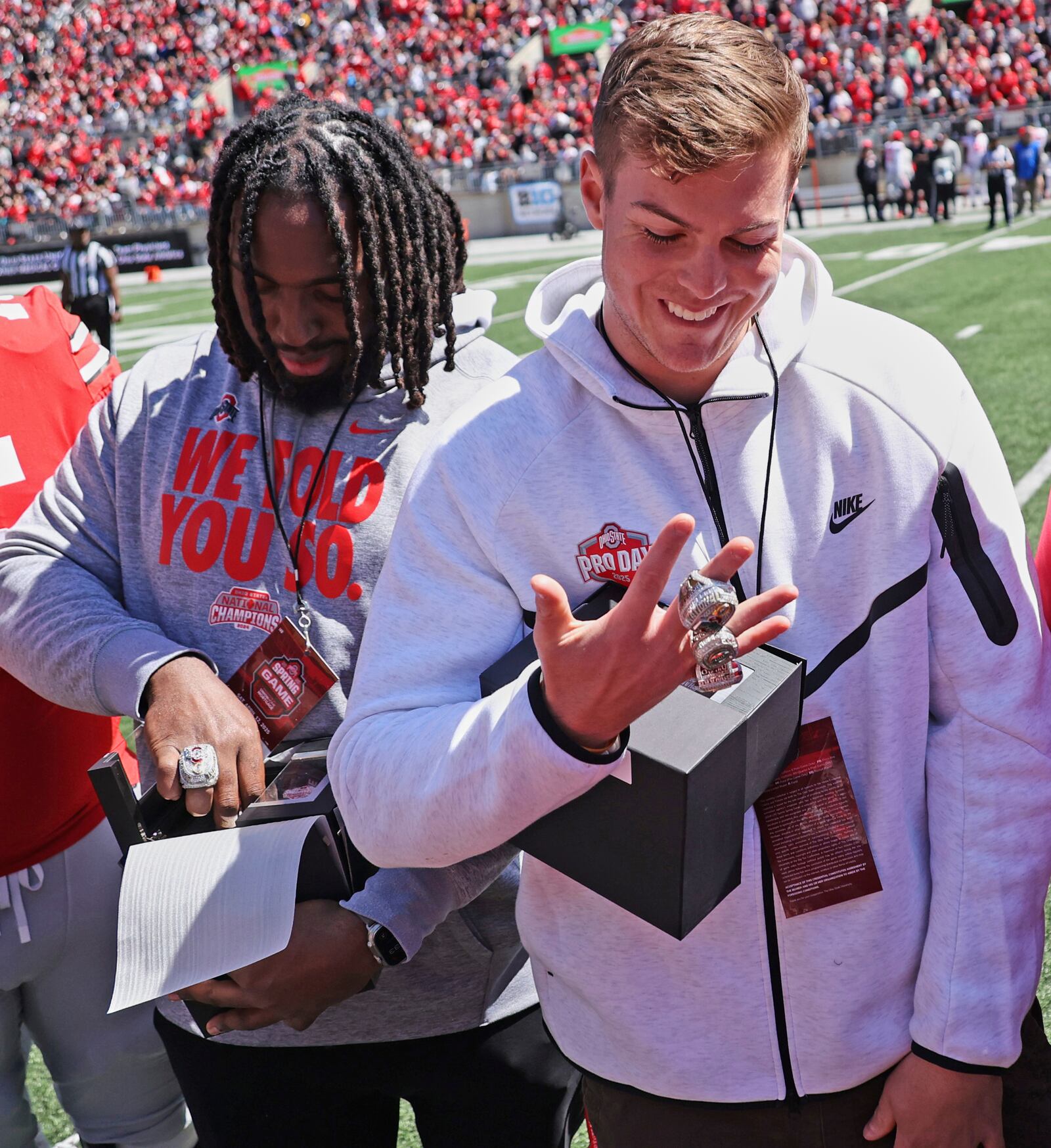Ohio State's Donovan Jackson, left, and Will Howard admire their NCAA college football championship rings during the school's spring football game on Saturday in Columbus. David Petkiewicz/CLEVELAND.COM