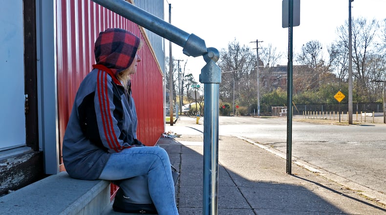 Tracy, a homeless woman living on the streets of Springfield, sits on some steps along North Jackson Street waiting for the Springfield Soup Kitchen to open Wednesday, Nov. 23, 2022. Tracy says she's tried unsuccessfully to get help from different agencies and for now is sleeping on the front porch of an abandoned house at night. BILL LACKEY/STAFF