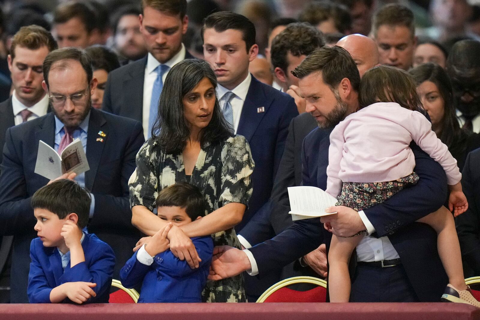 U.S. Vice President JD Vance, and his wife Usha Vance, with their daughter Mirabel, back to camera, and sons Vivek and Ewan, left, attend a Good Friday service inside St. Peter's Basilica at the Vatican, Friday, April 18, 2025. (AP Photo/Alessandra Tarantino)