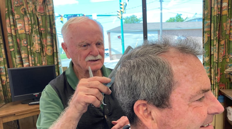 Don Maine trims up Bill Brougher’s hair in Maine’s barber shop for the last time. TOM STAFFORD/CONTRIBUTED
