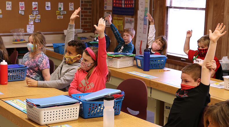 First grade students from Reid School raise their hands to answer a question at The Village. Students and teachers at Reid School had to be relocated to other buildings in the Clark Shawnee School District after Reid became unsafe. BILL LACKEY/STAFF