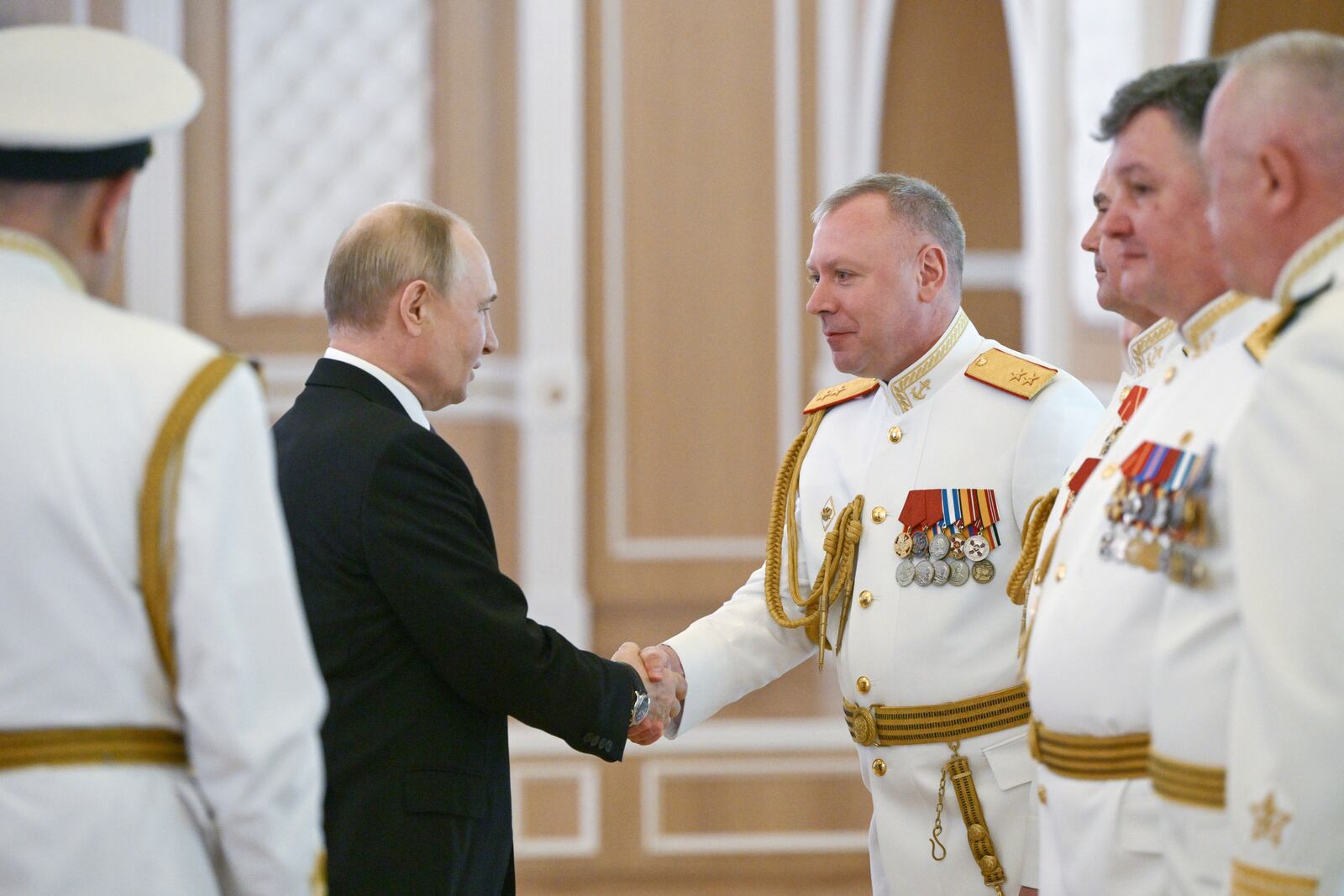 Russian President Vladimir Putin, left, shakes hands with Russian Navy officers during his visit to St. Petersburg on Navy Day, Russia, on Sunday, July 27, 2025. (Alexei Danichev, Sputnik, Kremlin Pool Photo via AP)
