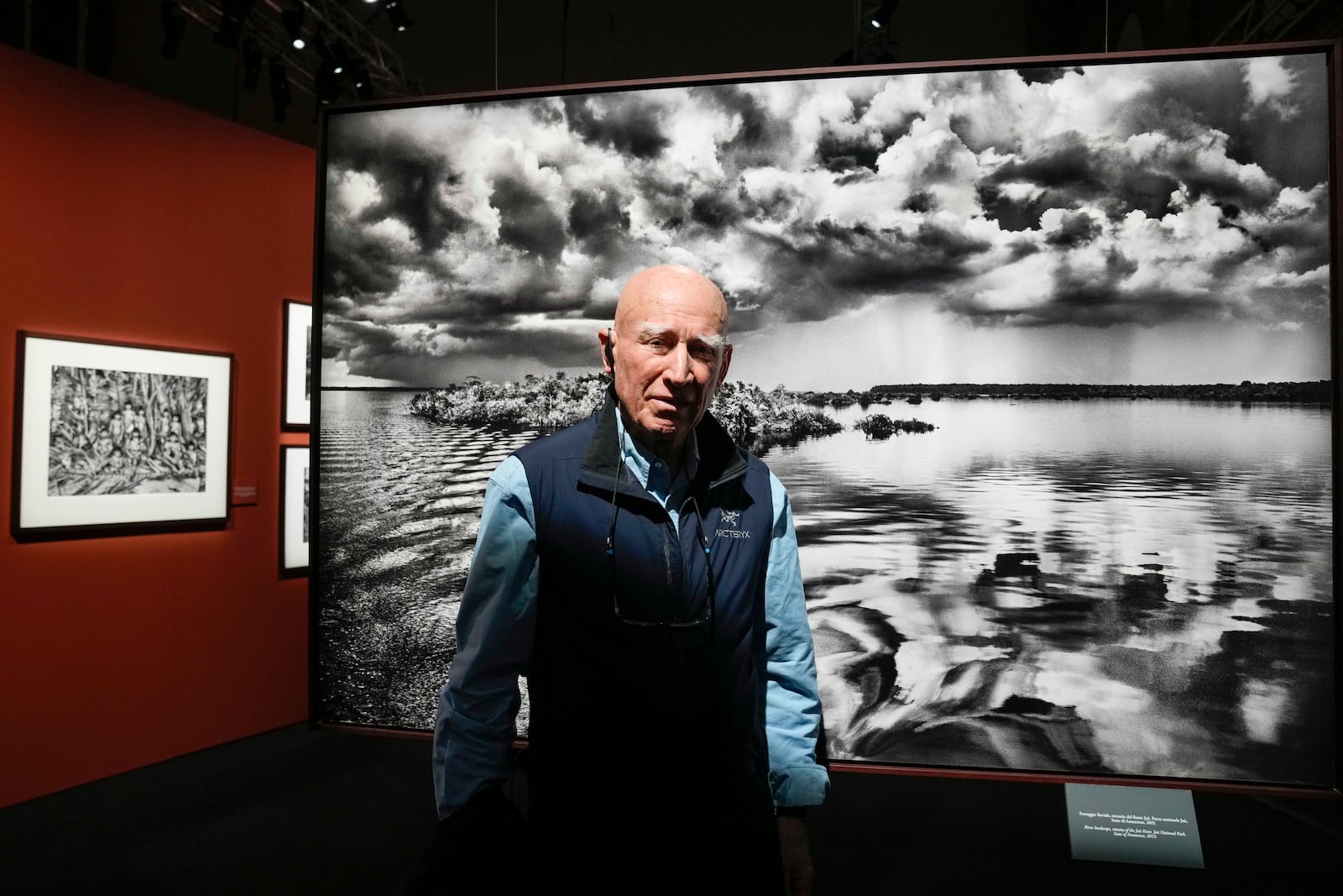 FILE - Brazilian photographer Sebastiao Salgado, poses in front of one of the pictures of his exhibition 'Amazonia', at the Fabbrica del Vapore, in Milan, Italy, Thursday, May 11, 2023. (AP Photo/Luca Bruno, file)
