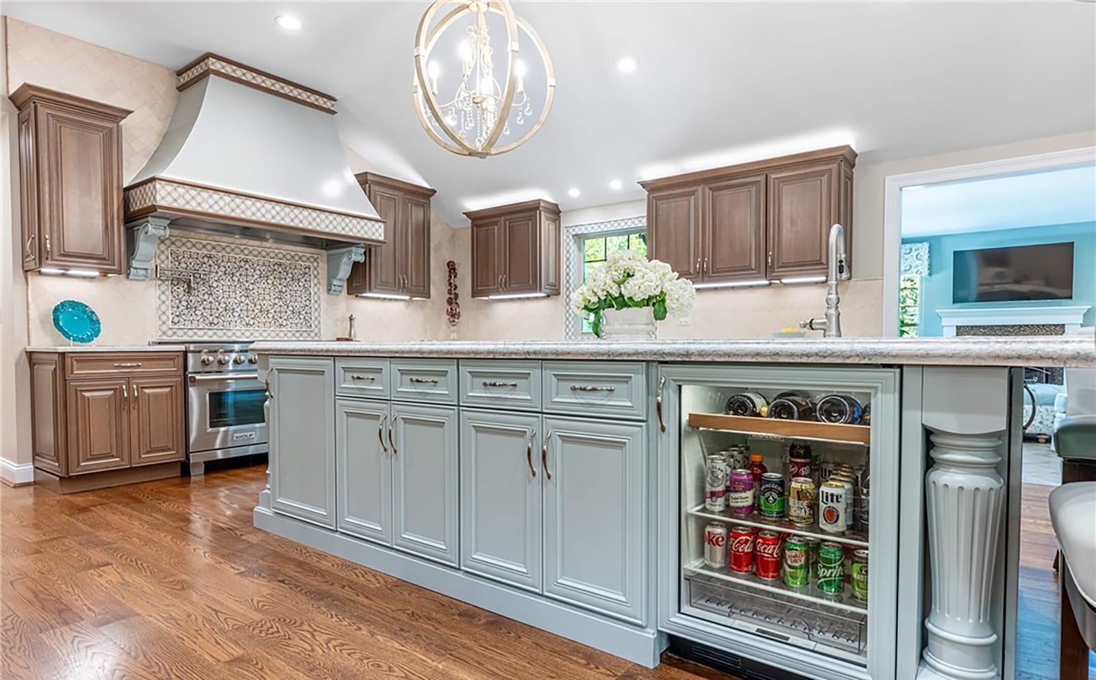 The kitchen has three sinks, including one in the 14 foot island, which has bar seating and a beverage cooler.