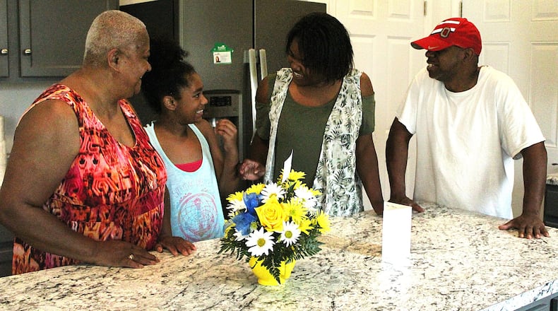 Clarice Crowe (left), her granddaughters Cymber Crowe and Brittany Alexander and Brittany’s father Michael stand in the kitchen of their new home. Clarice and her granddaughters will live in home on Clifton Ave. in Springfield. JEFF GUERINI/STAFF