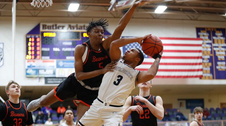 Beavercreek’s Siloam Baldwin leaps to block a shot by Springfield’s Jeff Tolliver during their Division I district semifinal game on Friday night at the Vandalia Butler Student Activity Center. The Beavers won 64-44. CONTRIBUTED PHOTO BY MICHAEL COOPER