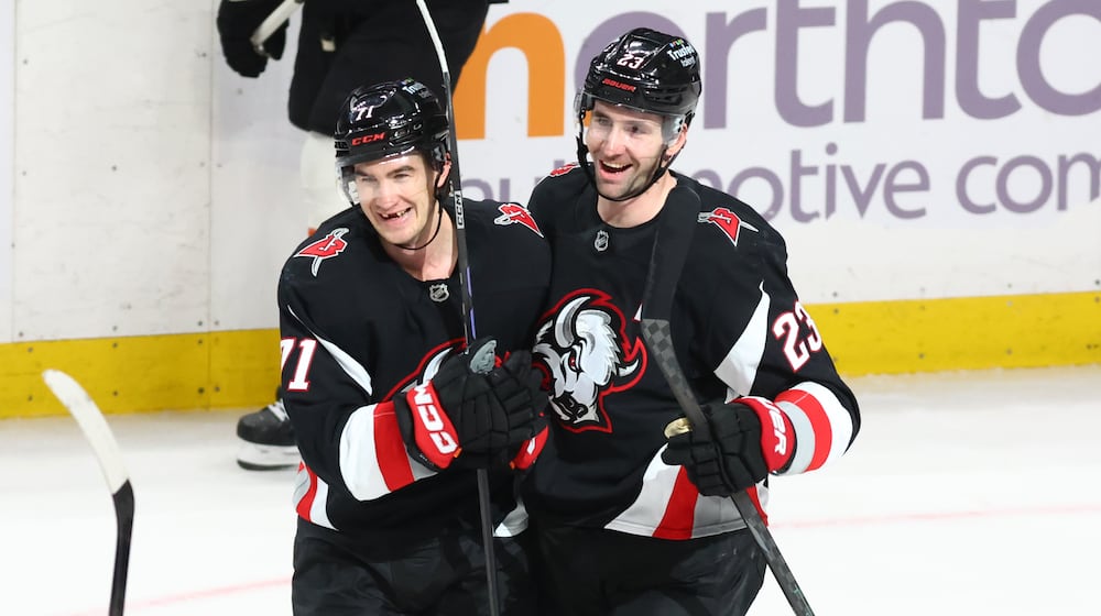 Buffalo Sabres center Ryan McLeod, left, celebrates his empty net goal with defenseman Mattias Samuelsson (23) during the third period of an NHL hockey game against the Philadelphia Flyers, Thursday, Dec. 18, 2025, in Buffalo, N.Y. (AP Photo/Jeffrey T. Barnes)
