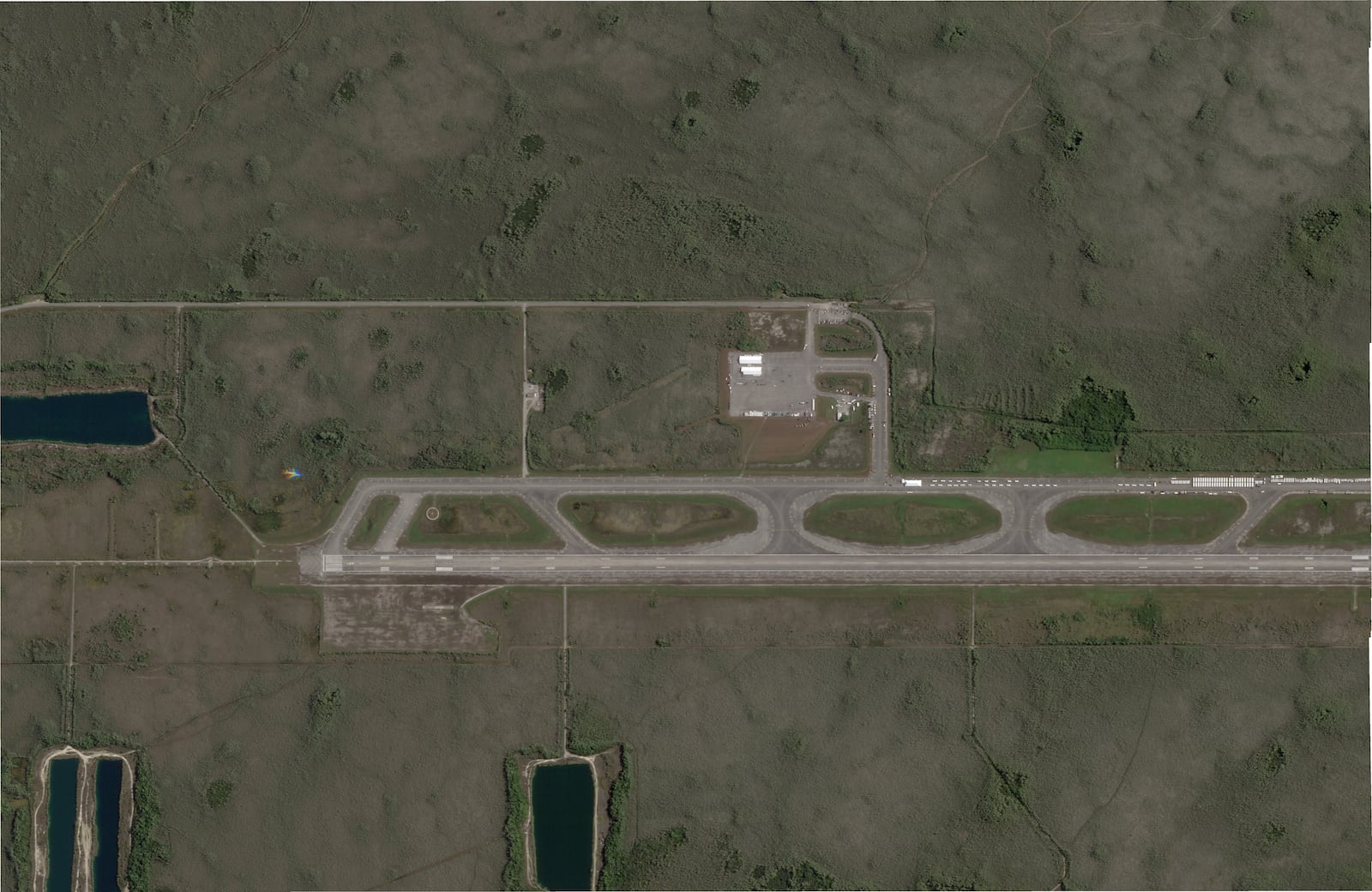 This satellite photo captured by Planet Labs PBC on June 25, 2025, shows white structures cropping up on an airstrip in Ochopee, Fla., in the Everglades, where state officials are building an immigration detention facility. (Planet Labs PBC via AP)